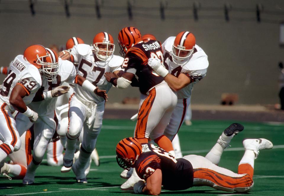 Browns linebackers Mike Junkin (54) and Clay Matthews (57) stop Cincinnati Bengals running back Stanley Wilson at Riverfront Stadium, Sept. 25, 1988.