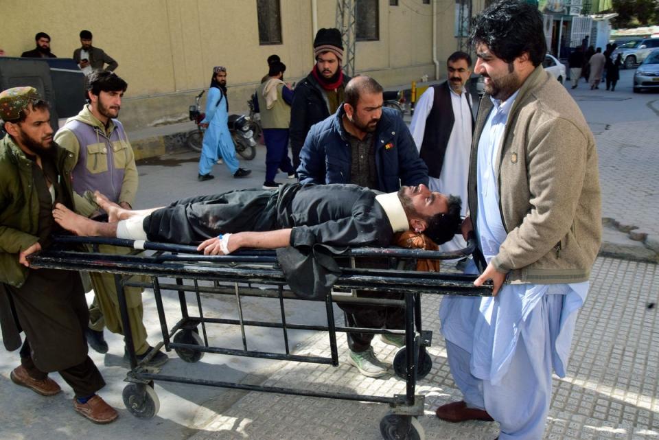 Workers and volunteers transport an injured victim from Pashin district's bomb blast, upon arrival at a hospital in Quetta (AP)