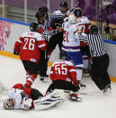Officials move in to break up a scuffle after a collision by a player from Norway with Austria goaltender Mathias Lange period of a men's ice hockey game at the 2014 Winter Olympics, Sunday, Feb. 16, 2014, in Sochi, Russia. (AP Photo/Julio Cortez)