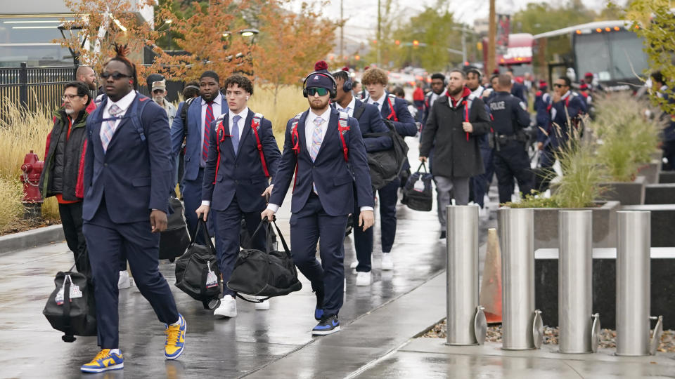 Arizona football players arrive at Rice-Eccles Stadium before their NCAA college football game against Utah Saturday, Nov. 5, 2022, in Salt Lake City. Arizona athletics, which has a $101.6 million budget and 21 sports, projects costs could increase by $4 million, according to Derek van der Merwe, an assistant vice president and chief operating officer for administration and athletics at the Pac-12 school. (AP Photo/Rick Bowmer)