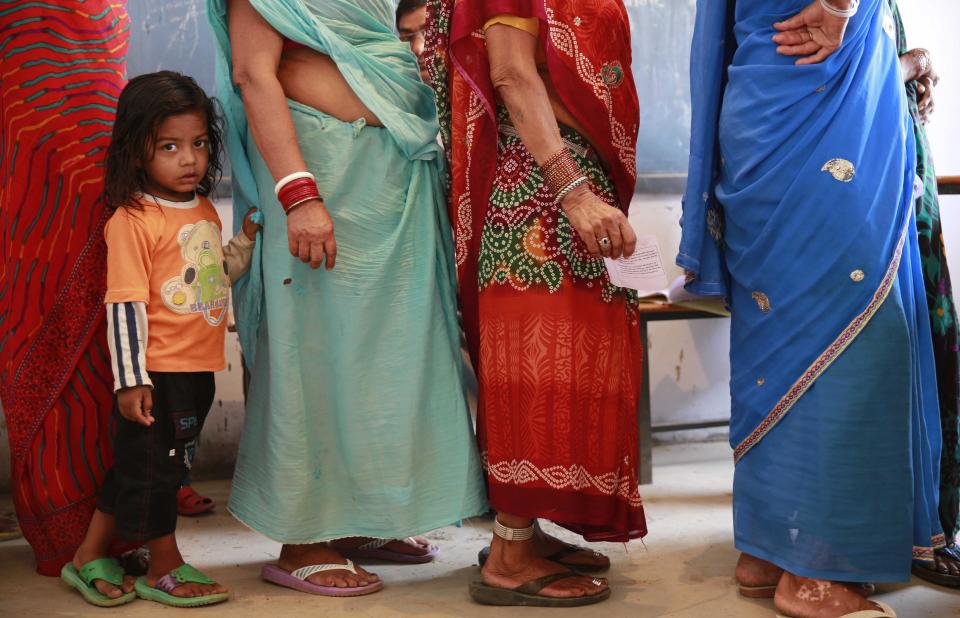 A child holds on to the sari of her grandmother standing in a queue to cast her vote in Rajnandgaon, in the central Indian state of Chhattisgarh, now the center of India's four-decade Maoist insurgency, Thursday, April 17, 2014. Indians cast ballots Thursday on the biggest day of voting in the country's weekslong general election, streaming into polling stations even in areas where rebels threatened violence over the plight of India's marginalized and poor. The state of Chhattisgarh itself was formed only in 2000, carved from its western neighbor Madhya Pradesh based on its large tribal population. (AP Photo/Rafiq Maqbool)