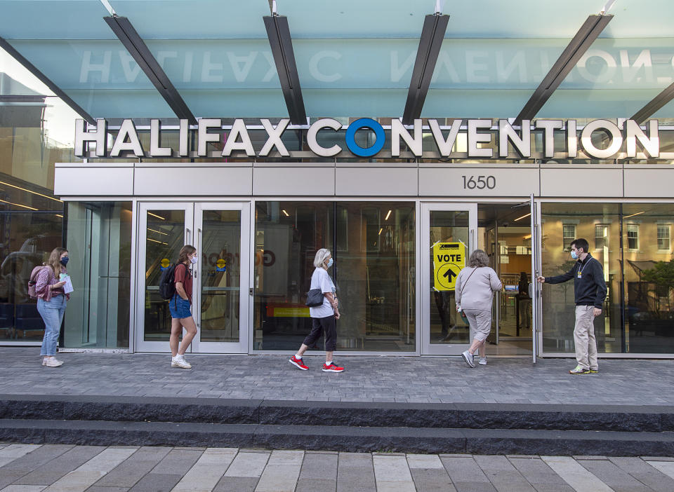 Voters follow social distancing measures as they line up at the Halifax Convention Centre as they prepare to vote in the federal election in Halifax on Monday, Sept. 20, 2021. (Andrew Vaughan/The Canadian Press via AP)