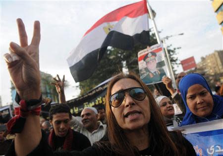 An Egyptian woman gestures during a protest against what they say is Qatar's backing of ousted Egyptian president Mohamed Mursi's government, outside the Qatari Embassy in Cairo November 30, 2013. REUTERS/Stringer