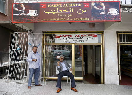 File photo of a Syrian man (R) who had fled the war in his homeland sitting outside his coffee shop in a low-income neighborhood of Ankara, Turkey, September 29, 2015. REUTERS/Umit Bektas/Files