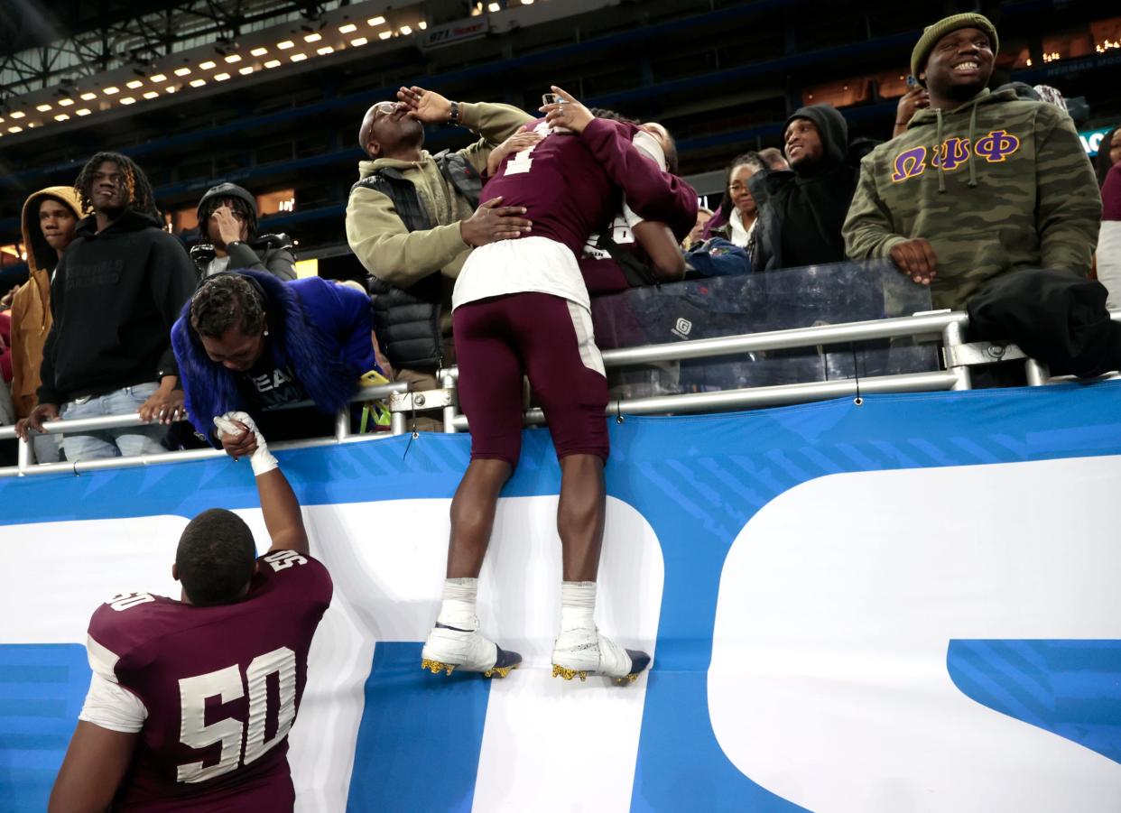 Harper Woods' Malachi McGhee (50) and Jacob Oden celebrate with family and friends after the 33-27 win in the Division 4 football state title game on Saturday, Nov. 25, 2023, at Ford Field.