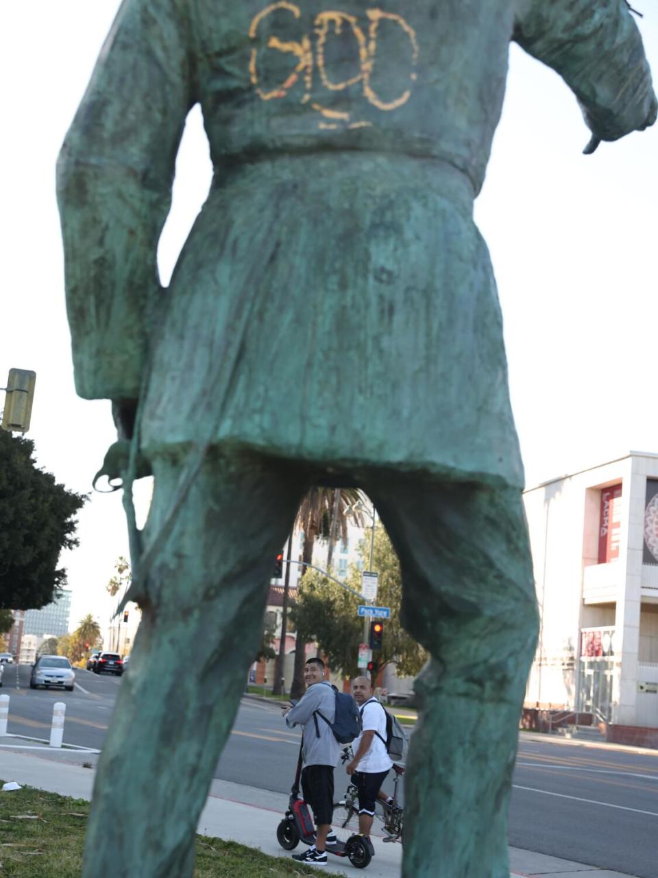 People look at the front of the now defaced statue of General Harrison Gray Otis at MacArthur