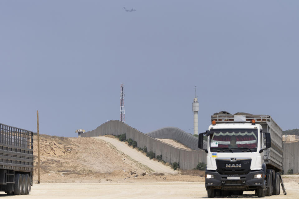 A military aircraft flies above as as a truck carrying humanitarian aid supplies bound for the Gaza Strip drives on the Palestinian side of the Erez crossing between southern Israel and Gaza, Wednesday, May 1, 2024. (AP Photo/Ohad Zwigenberg)