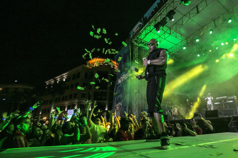 Flo Rida throws out money on the Ford stage during SunFest in downtown West Palm Beach on May 5, 2017.