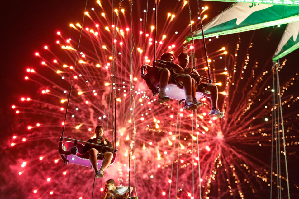 <p>People hang from the Sky Flyer ride at the State Fair Meadowlands during a Fourth of July fireworks display, Friday, July 3, 2015, in East Rutherford, N.J. (Photo: Julio Cortez/AP) </p>