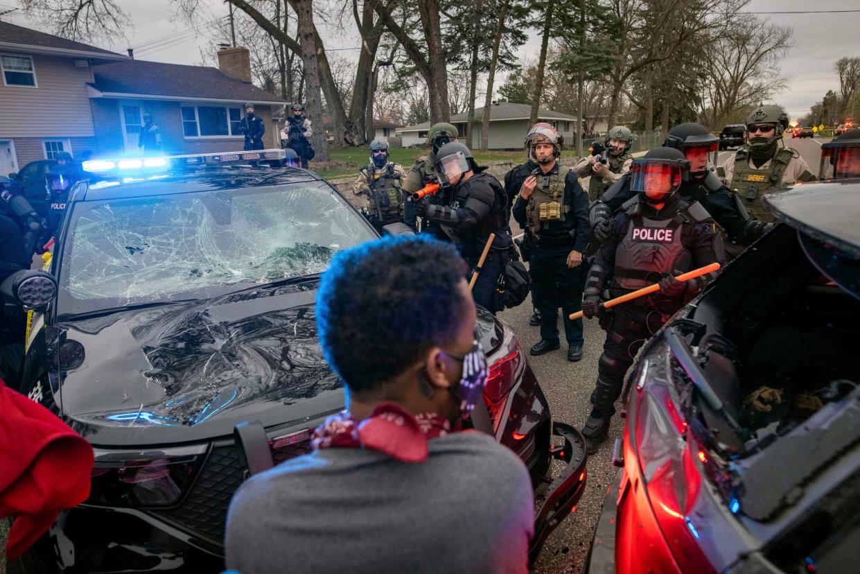 Protesters clash with police near the site where a family said a man was shot and killed by local law enforcement, Sunday, April 11, 2021, in Brooklyn Center, Minn.