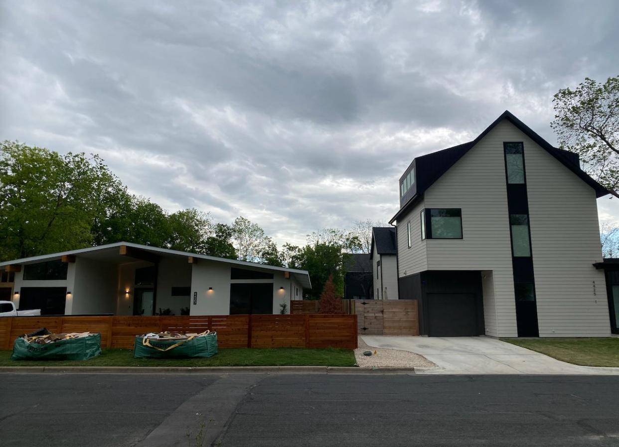 One of four smaller homes built on a single lot (right), adjacent to a 5-bedroom single-family home on a similar lot in Austin, Texas.