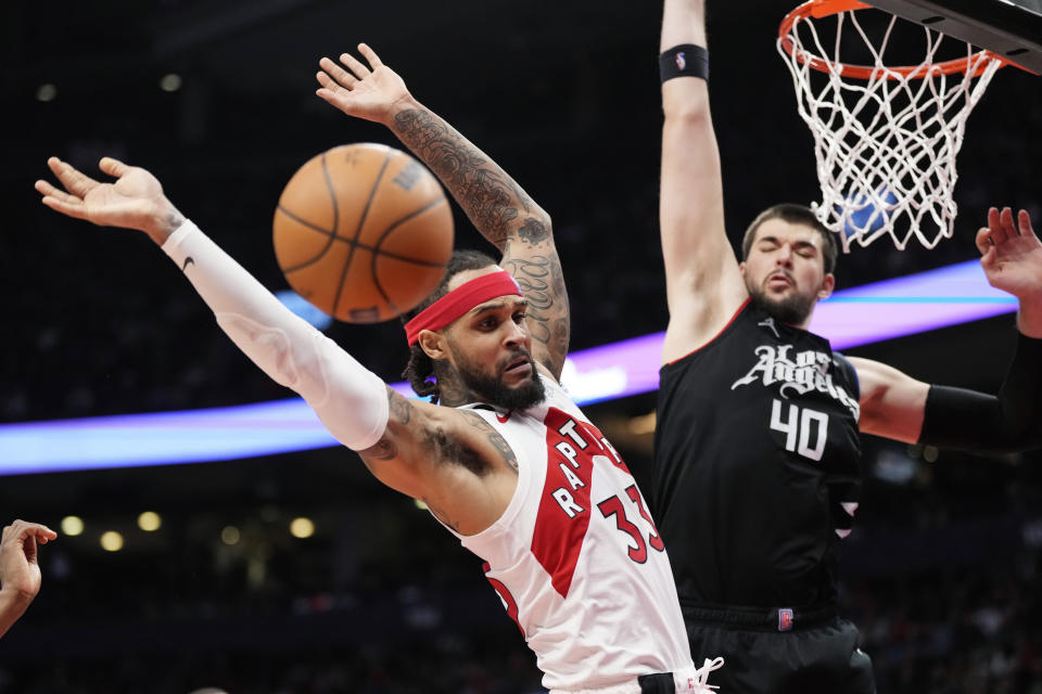 Toronto Raptors guard Gary Trent Jr. (33) loses the ball as Los Angeles Clippers center Ivica Zubac (40) defends during the second half of an NBA basketball game Tuesday, Dec. 27, 2022, in Toronto. (Frank Gunn/The Canadian Press via AP)