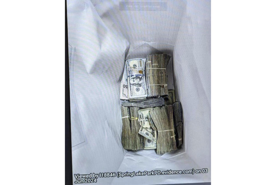 This photo supplied by the U.S. Attorney's Office for Minnesota shows cash from a bag that was left at the home of a juror in a massive fraud case, June 2, 2024, outside Minneapolis, Minn. Authorities have confiscated cellphones and taken all seven defendants into custody as investigators try to determine who attempted to bribe the juror to acquit them on charges of stealing more than $40 million from a program meant to feed children during the pandemic. (U.S. Attorney's Office for Minnesota via AP)