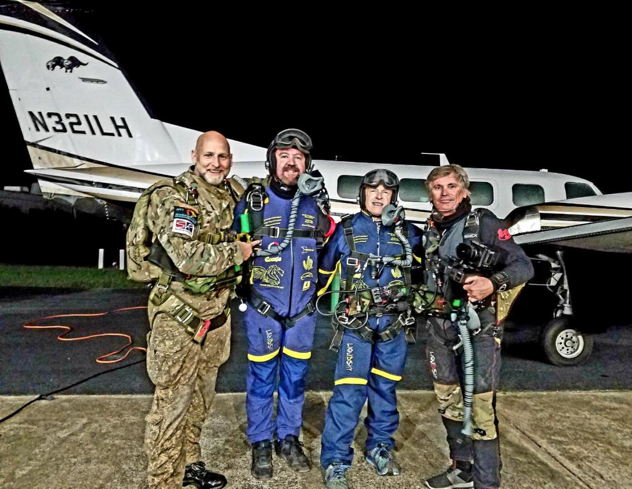 xxx , Tom Noonan III, Jim Wigginton and xxx take a photo before preparing to do a tandem skydive at a 41,000 feet altitude.