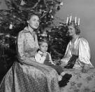 <p>Ingrid Bergman incorporates her Swedish traditions into the holidays, as she poses by her Christmas tree with her son in 1952. </p>