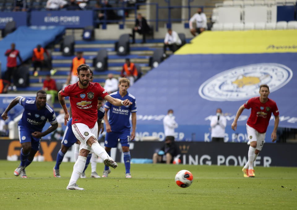 Manchester United's Bruno Fernandes, front, scores his side's opening goal from the penalty spot during the English Premier League soccer match between Leicester City and Manchester United at the King Power Stadium, in Leicester, England, Sunday, July 26, 2020. (Carl Recine/Pool via AP)