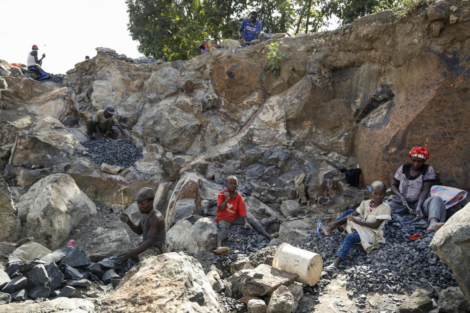 Kevin Mutinda, 7, center, his sister Irene Wanzila, 10, 2nd right, and their mother Florence Mumbua, right, work to break rocks with a hammer, after Mumbua say she was left without a choice after she lost her cleaning job at a private school when coronavirus pandemic restrictions were imposed, at Kayole quarry in Nairobi, Kenya Tuesday, Sept. 29, 2020. The United Nations says the COVID-19 pandemic risks significantly reducing gains made in the fight against child labor, putting millions of children at risk of being forced into exploitative and hazardous jobs, and school closures could exacerbate the problem. (AP Photo/Brian Inganga)