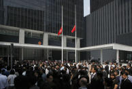 Hong Kong government officials pay tribute to victims who were killed in a ferry collision, with flying Chinese and Hong Kong flags at half-mast in the Central Government Office in Hong Kong Thursday, Oct. 4, 2012. Shock over Monday's crash, which left 38 dead, gave way to outrage Wednesday over what experts concluded was human error. (AP Photo/Kin Cheung)