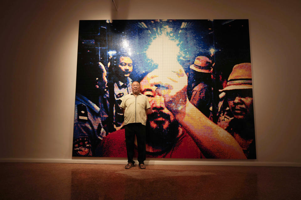 Chinese artist Ai Weiwei poses in front of a self portrait made by lego at the San Giorgio deconsecrated church in Venice, Italy, Friday, Aug. 26, 2022. Chinese artist Ai Weiwei lampoons the surveillance culture and social media with his first ever glass sculpture, made on the Venetian island of Murano, that stands as a warning to the world: "Memento Mori,'' or Latin for "Remember You Must Die." (AP Photo/Luca Bruno)