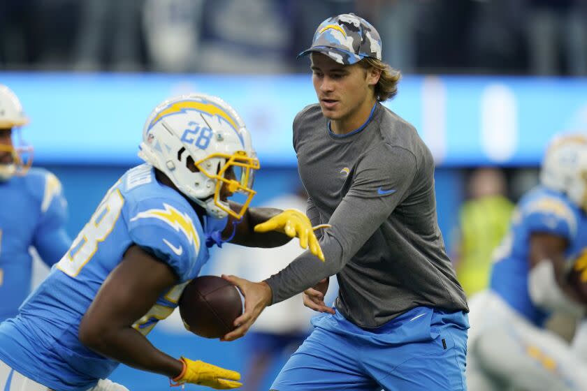 Los Angeles Chargers quarterback Justin Herbert hands off to running back Isaiah Spiller.