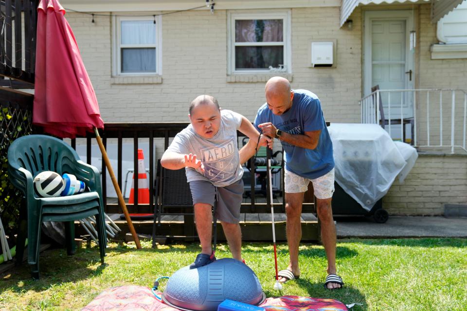 Alvaro "Albie" Nieves gets help from his father, Al Nieves, while doing exercises to build his leg muscles. Nieves, 23, has cerebral palsy. Thursday, August 9, 2023