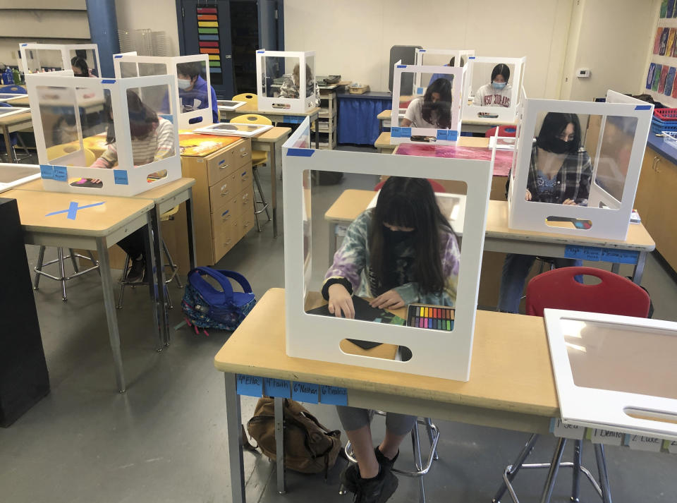 Socially distanced and with protective partitions students work on an art project during class at the Sinaloa Middle School in Novato, Calif., on Tuesday, March 2, 2021. The school just reopened Monday, Feb. 22, 2021, for in-person learning. (AP Photo/Haven Daily)