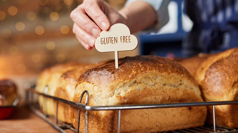 Sales assistant putting gluten free label on bread