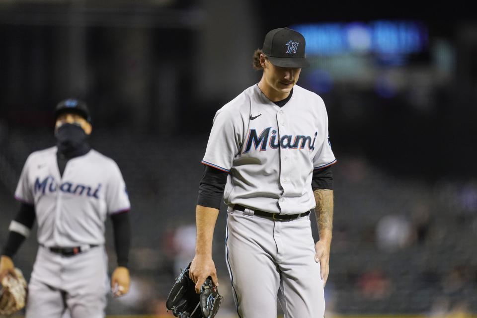 Miami Marlins starting pitcher Jordan Holloway, right, walks off the field as he is replaced while Marlins second baseman Isan Diaz, left, looks on during the fourth inning of a baseball game against the Arizona Diamondbacks, Monday, May 10, 2021, in Phoenix. (AP Photo/Ross D. Franklin)