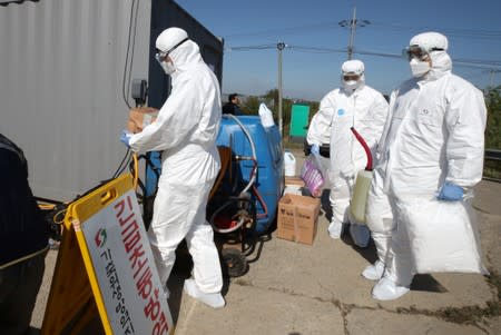 Quarantine officials wearing protective gear enter a pig farm involved in African swine fever in Paju