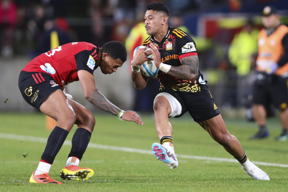 Etene Nanai-Seturo, right, of the Chiefs runs at a defender during the Super Rugby Pacific final between the Chiefs and the Crusaders in Hamilton, New Zealand, Saturday, June 24, 2023. (Aaron Gillions/Photosport via AP)
