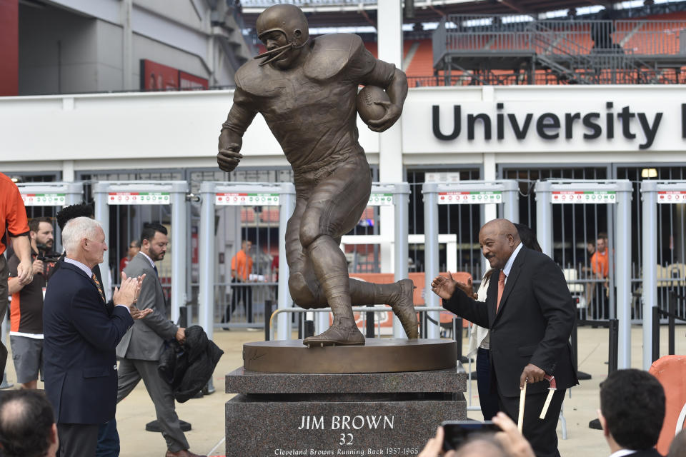 FILE - Former Cleveland Browns Pro Football Hall of Famer Jim Brown, right, is honored during a ceremony and statue outside FirstEnergy Stadium before an NFL football game against the Baltimore Ravens, Sunday, Sept. 18, 2016, in Cleveland. The 19-foot, 4,000-pound statue of Kobe Bryant in downtown Los Angeles is just the latest example of a sports team honoring a player with this kind of larger-than-life presence. (AP Photo/David Richard, File)