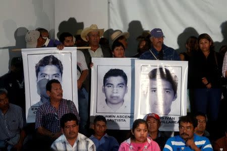 Relatives of the 43 missing students of Ayotzinapa Teacher Training College Raul Isidro Burgos hold up posters as they take part in a news conference in Mexico City October 29, 2014. REUTERS/Edgard Garrido