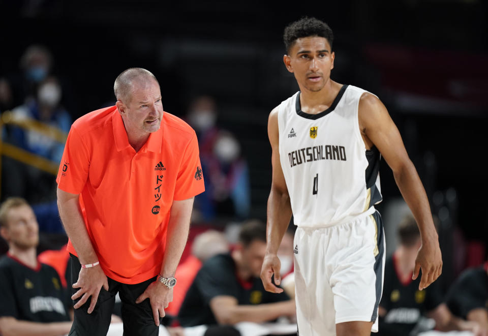 Germany head coach Henrik Rodl, left, interacts with player Maodo Lo during men's basketball preliminary round game against Italy at the 2020 Summer Olympics, Sunday, July 25, 2021, in Saitama, Japan. (AP Photo/Charlie Neibergall)