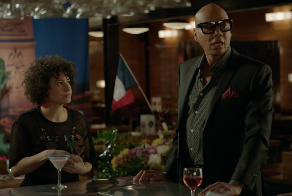 Ilana Glazer as Ilana Wexler and RuPaul as Marcel chat with some coworkers in "Broad City"