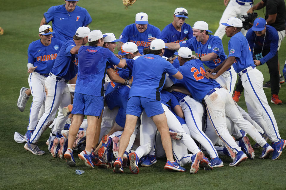 Florida players and coaches celebrate on the field after defeating South Carolina in an NCAA college baseball tournament super regional game Saturday, June 10, 2023, in Gainesville, Fla. (AP Photo/John Raoux)