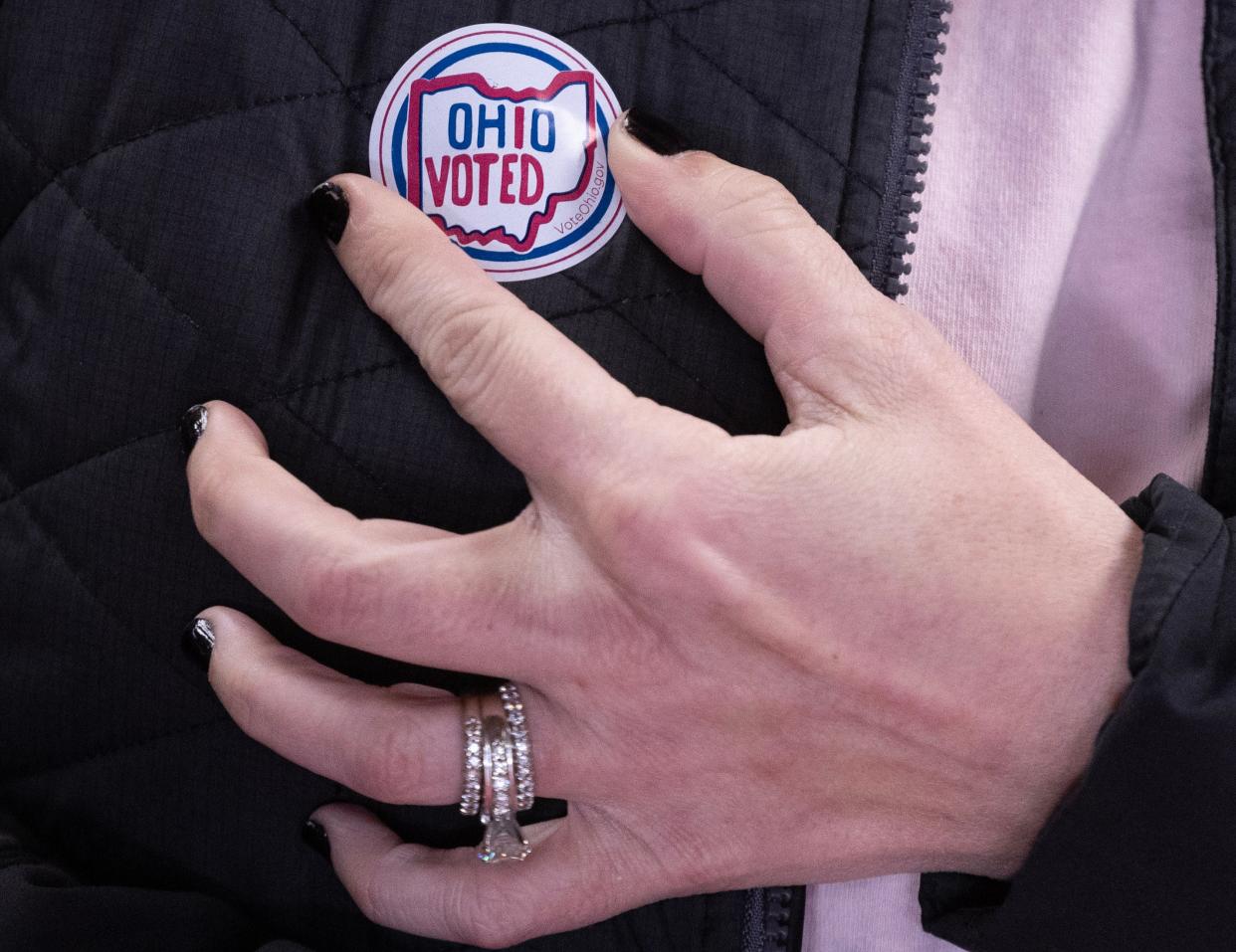 Krista Boyer of Hartville affixes her voting sticker after casting her votes at the Hartville Church of the Brethren Tuesday, March 19, 2024.