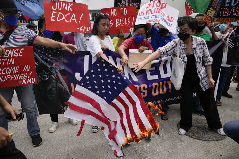 Manifestantes filipinos queman una bandera de Estados Unidos en protesta por la visita del secretario de Defensa de EE.UU., Lloyd Austin, fuera del Camp Aguinaldo, en Manila. (AP/Aaron Favila)