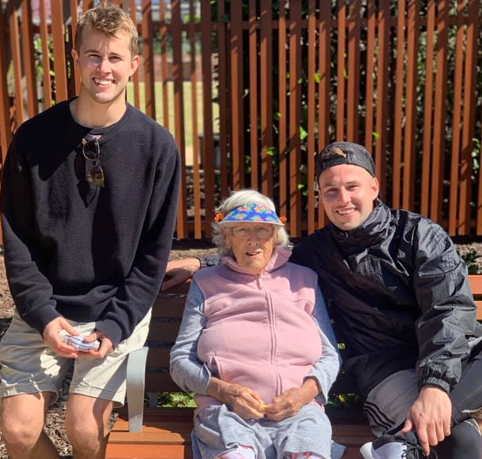 Sydney brothers Logan (right) and Dane Hopper (left) with their grandmother sitting on a park bench smiling.