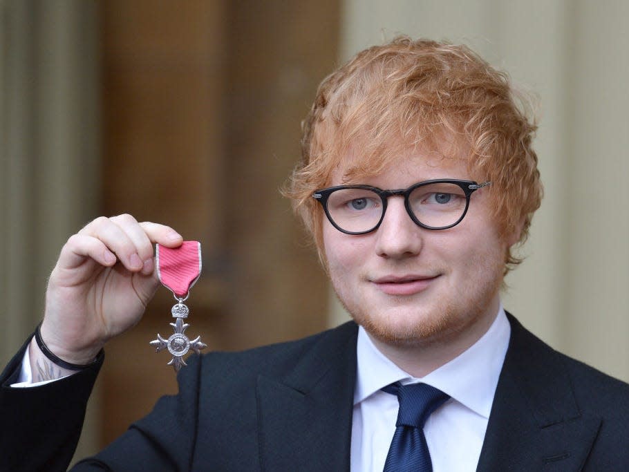 Ed Sheeran holds up his MBE (Member of the Order of the British Empire) medal