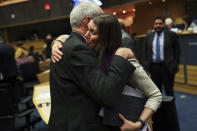 Scottish European Parliament member Aileen McLeod, right, hugs British European Parliament member Richard Corbett at the end of an European Parliament's constitutional affairs committee meeting for Brexit at the European Parliament in Brussels, Thursday, Jan. 23, 2020. Hours after the deal received royal assent from Queen Elizabeth II, an influential European Parliament's committee endorsed the withdrawal agreement, paving the way for Britain to leave the 28-country bloc next week. (AP Photo/Francisco Seco)