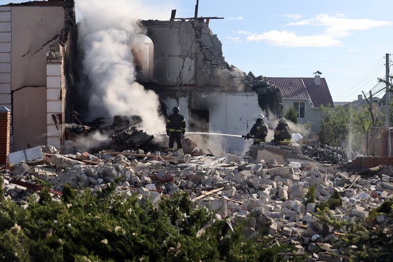 Los bomberos apagan una casa después de un ataque con misiles rusos contra Kharkiv, al noreste de Ucrania