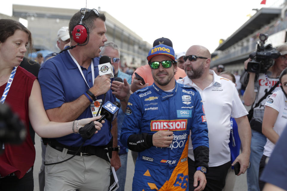 FILE - In this May 18, 2019, file photo, Fernando Alonso, of Spain, is interviewed as he walked from the pit area after qualifications ended for the Indianapolis 500 IndyCar auto race at Indianapolis Motor Speedway in Indianapolis. Alonso will once again attempt to complete motorsports' version of the Triple Crown with a return to the Indianapolis 500 in May with McLaren.(AP Photo/Michael Conroy, File)