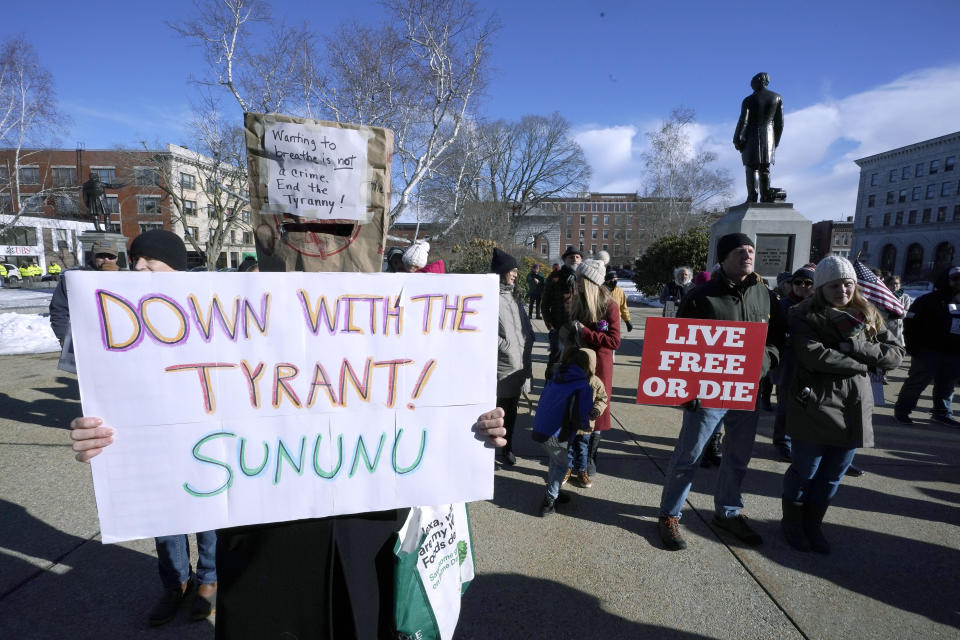 FILE - In this Thursday, Jan. 7, 2021 file photo, people protest outside the Statehouse in Concord, N.H., as Gov. Chris Sununu is inaugurated at noon for his third term as governor. A measure that recently passed New Hampshire's Republican-led House would prohibit governors from indefinitely renewing emergency declarations, as Sununu has done every 21 days for the past year. It would halt emergency orders after 30 days unless renewed by lawmakers. (AP Photo/Charles Krupa)