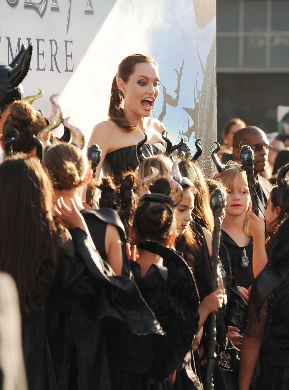 <p>Greeting a group of excited kids at the 2014 premiere of <em>Maleficent</em>.</p>