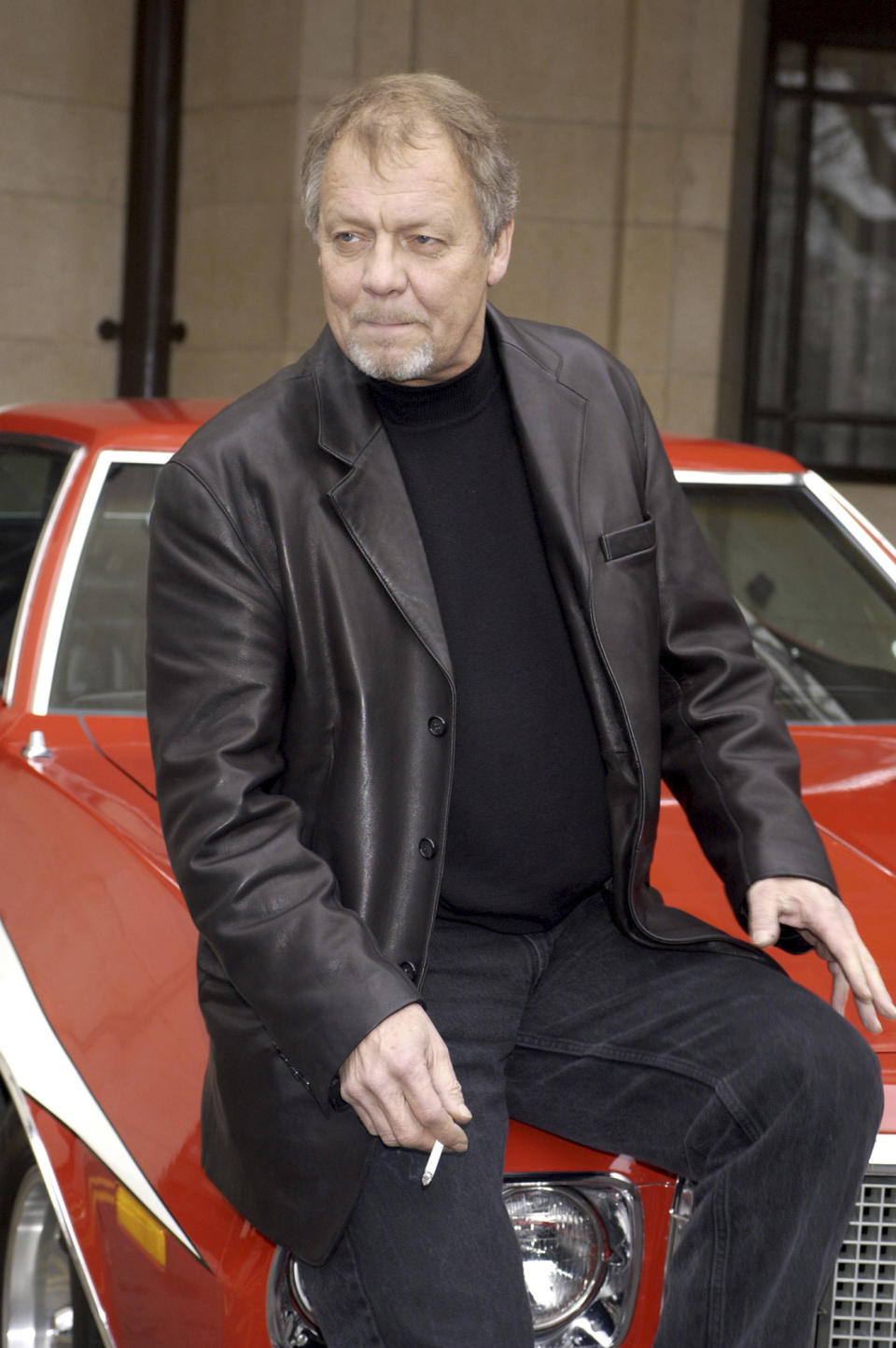 FILE - Actor David Soul sits outside the Dorchester Hotel ahead of the UK premiere of Starsky and Hutch, in London, March 11, 2004. The actor who earned fame as the blond half of a crime-fighting duo in the popular 1970s television series “Starsky and Hutch” has died. David Soul was 80. His wife, Helen Snell, said Friday, Jan. 5, 2024 that Soul died on Thursday "after a valiant battle for life in the loving company of family.” (Yui Mok/PA via AP, File)