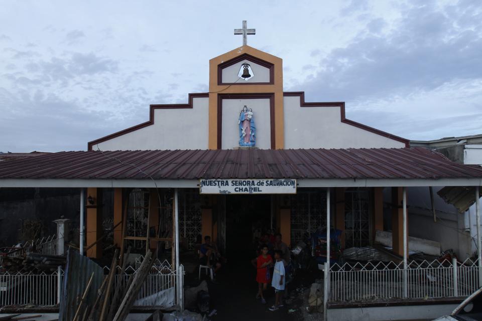 Residents take shelter in a damaged chapel after the Super typhoon Haiyan battered Tacloban city in central Philippines