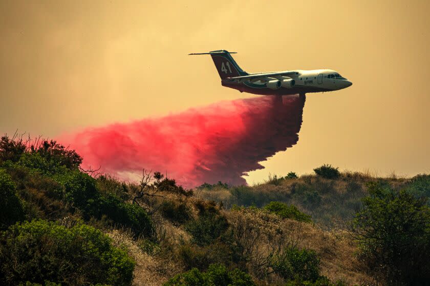 RIVERSIDE COUNTY, CA - JULY 15: An air tanker drops fire retardant as Rabbit Fire rages through Lamb Canyon threatening Beaumont on Saturday, July 15, 2023 in Riverside County, CA. (Irfan Khan / Los Angeles Times)