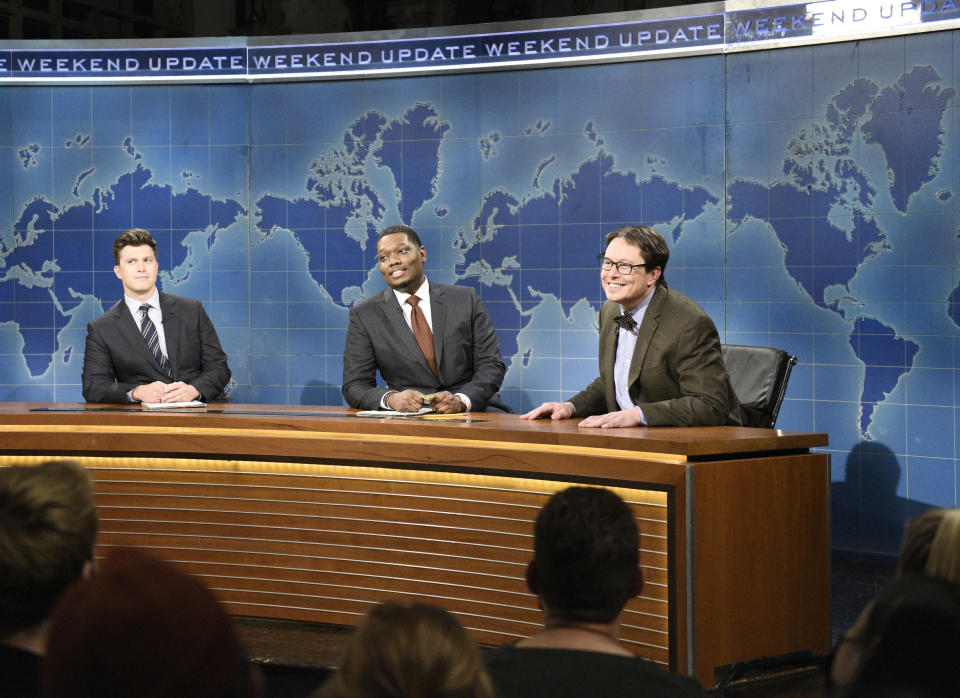 This image released by NBC shows, from left, Colin Jost, Michael Che, and host Elon Musk as financial expert Lloyd Ostertag during the "Weekend Update" sketch on "Saturday Night Live," in New York on May 8, 2021. (Will Heath/NBC via AP)