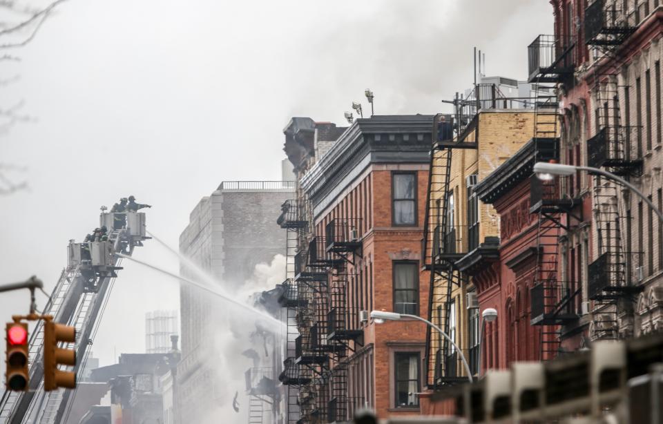 NEW YORK, UNITED STATES - MARCH 26: Smoke rises as the firefighters extinguish a fire caused by a blast occurred at a building in East Village district of New York, United States on March 26, 2015. Local media reports that at least six people were injured but it is unclear if anyone was trapped inside either building. No casualties have been reported. The cause of the explosion will be clear after the investigation. (Photo by Cem Ozdel/Anadolu Agency/Getty Images)