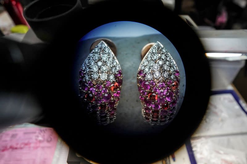 An employee micro sets diamonds in earrings at a jewellery manufacturing factory in Mumbai